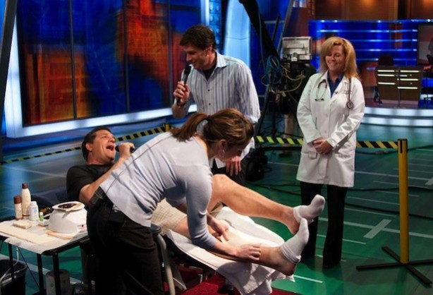 Nancy Mello watches as Mike and Mike's Mike Golic gets waxed on the set. 