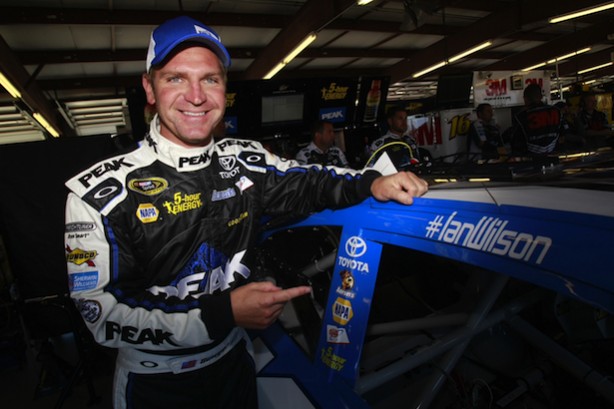 Clint Bowyer poses with his car next to Ian Wilson's name. (Photo courtesy of Michael Waltrip Racing)