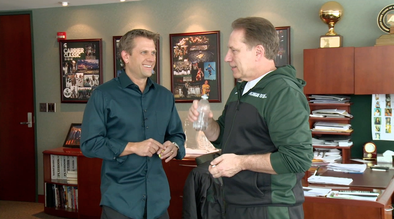 Sport Science's John Brenkus (l) talks with Michigan State's Tom Izzo (r), as the coach swallows an ingestible thermometer to measure his core body temperature.